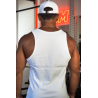 Homme vu de dos portant un débardeur blanc sans manches dans une salle de sport, casquette blanche et collier doré. On voit l’in