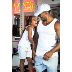 Homme musclé en débardeur blanc et casquette blanche riant avec une jeune fille au sourire éclatant, dans une salle de sport, li