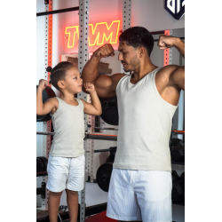 Joueur adulte et enfant en débardeurs beige, se faisant face et montrant des muscles dans une salle de sport.