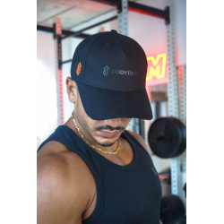 Casquette noire en coton avec logo BodyTime orange sur le côté et attache orange, porté par un homme en salle de sport.