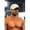 Casquette beige en coton avec attache orange portée par un homme torse nu, collier doré et tatouages visibles.