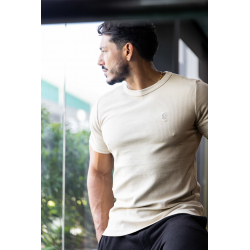 Homme élégant portant un t-shirt beige ESSENTIAL près du corps, vue de profil, intègre logo discret sur la poitrine.